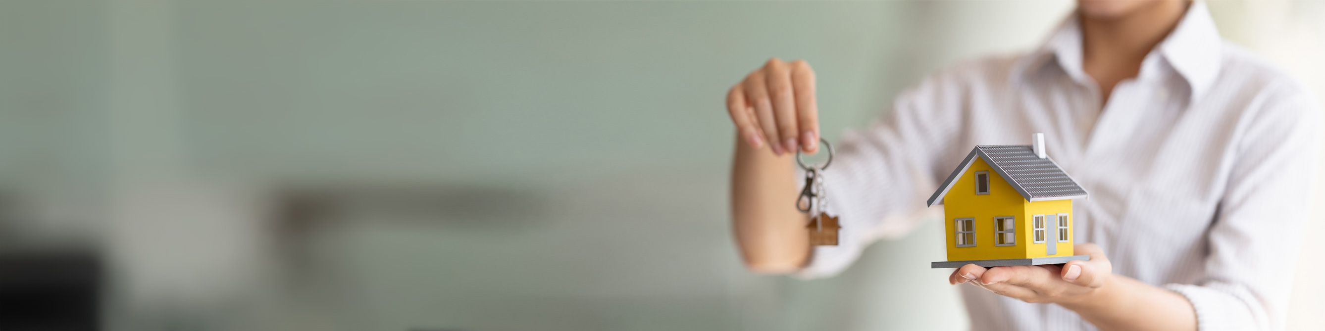 Einbruchdiebstahl Mann mit Schlüssel und kleinem gelben Haus in der Hand.