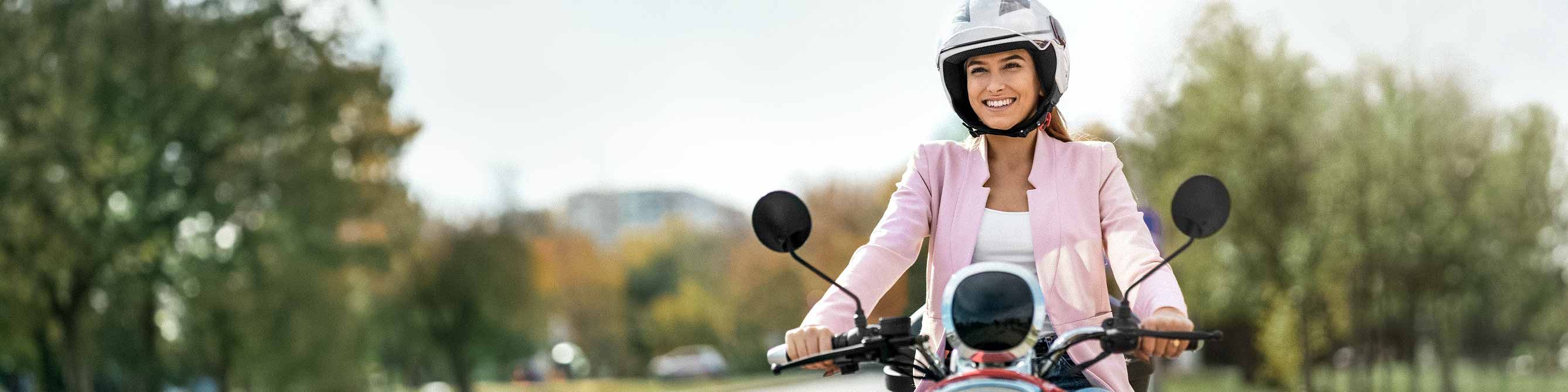 Rollerversicherung: Frau fährt auf einem Roller