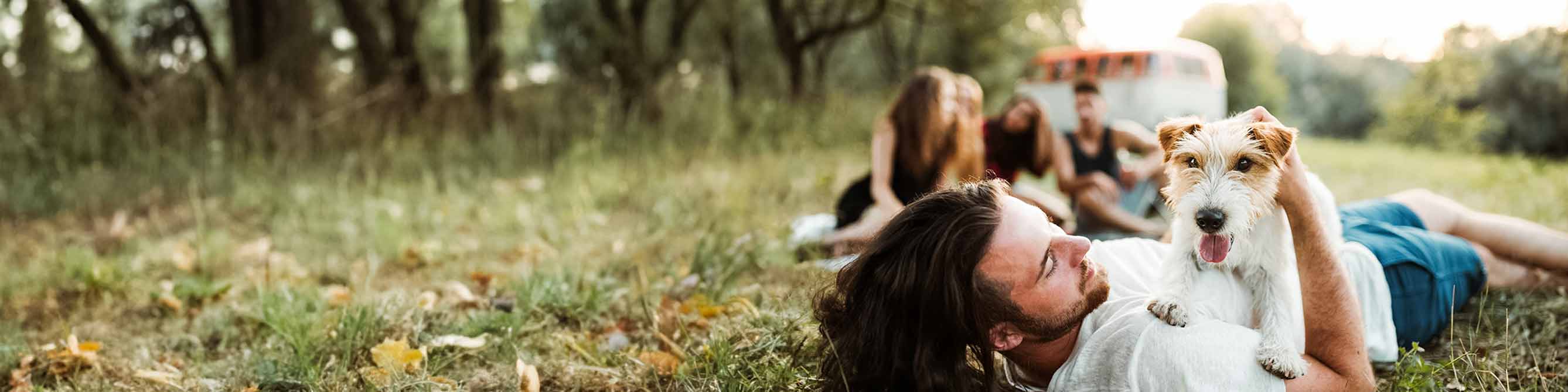 Provinzial-Kunde liegt mit seinem krankenversicherten Hund auf einer Wiese