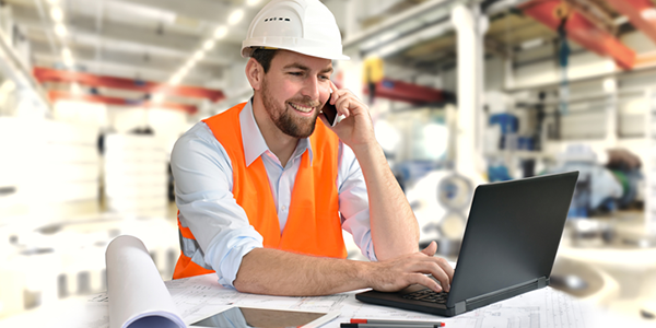 Bauleiter an Laptop auf Baustelle