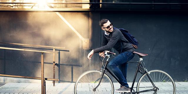 Ein junger Fahrradfahrer schaut lachend über seine Schulter.